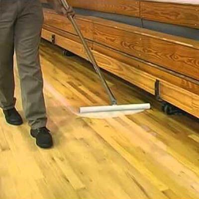 Man rescreening hardwood gym floor