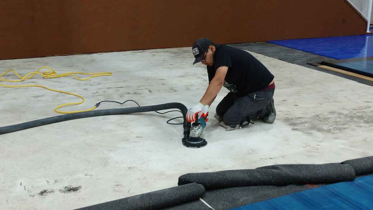 A crew from Clean Air Flooring Removal grinds the concrete to remove a hump.