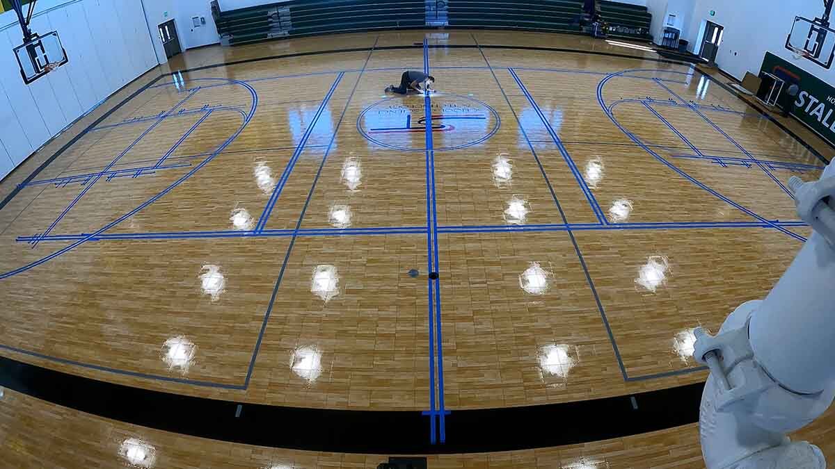 Preparing to paint game lines on the gym floor.