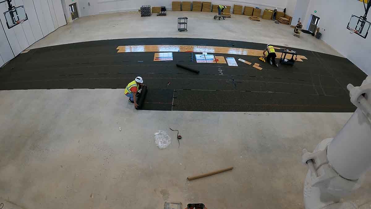 Installing rubber underlayment at School of Science and Technology Northeast High School